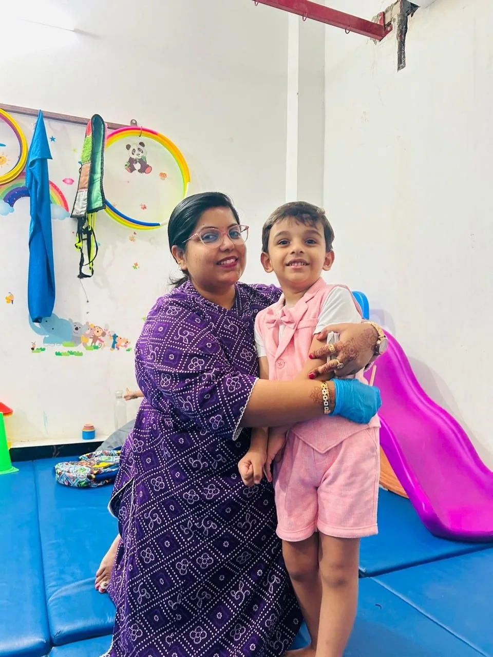 A smiling child and adult together in the Premdhara therapy room
